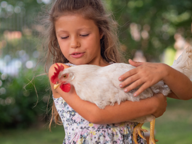 Authentic moment of happy little smiling girl is holding a white